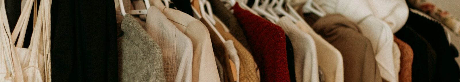 brown and white coat hanged on rack