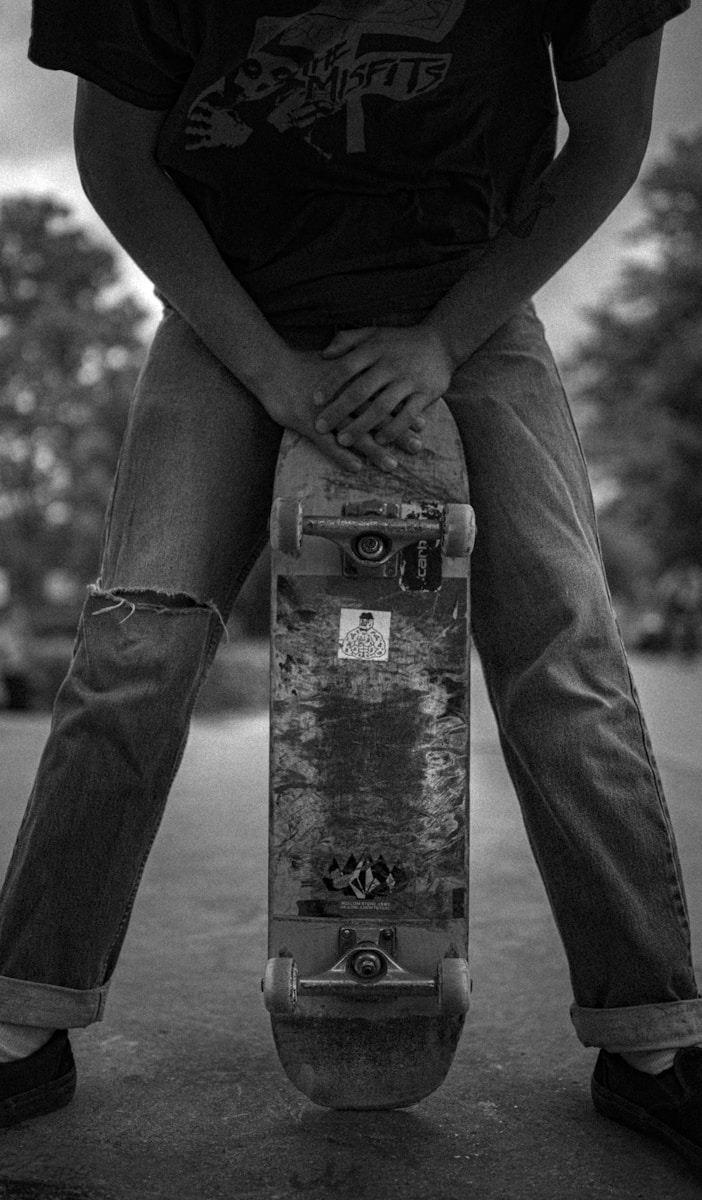 Photo by Tim Zänkert grayscale photo of person in black long sleeve shirt and black pants standing on concrete post